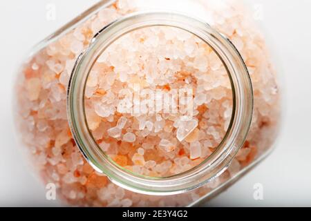 Große Kristalle von rosa Himalaya-Salz im Glas. Weißer Hintergrund. Draufsicht. Nahaufnahme. Stockfoto