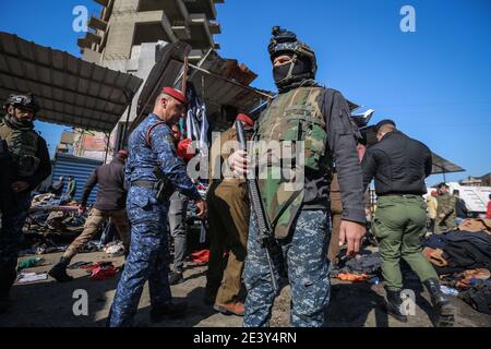 Bagdad, Irak. Januar 2021. Mitglieder irakischer Sicherheitskräfte versammeln sich am Schauplatz eines zweifachen Selbstmordattentats auf einem Straßenmarkt, der gebrauchte Kleidung im Zentrum von Bagdad verkauft. Mindestens 28 Menschen wurden bei einem zweifachen Selbstmordanschlag getötet und mehr als 70 verletzt, der auf das geschäftige Geschäftsviertel Bab Al Sharqi abzielte, nachdem sich zwei Selbstmordattentäter bei der Verfolgung durch Sicherheitskräfte in die Luft gesprengt hatten. Quelle: Ameer Al Mohammedaw/dpa/Alamy Live News Stockfoto
