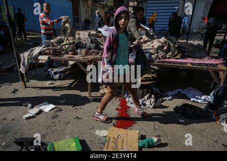 Bagdad, Irak. Januar 2021. Ein irakischer Junge geht über Blut an den Ort eines zweifachen Selbstmordattentats auf einem Straßenmarkt, der gebrauchte Kleidung im Zentrum von Bagdad verkauft. Mindestens 28 Menschen wurden bei einem zweifachen Selbstmordanschlag getötet und mehr als 70 verletzt, der auf das geschäftige Geschäftsviertel Bab Al Sharqi abzielte, nachdem sich zwei Selbstmordattentäter bei der Verfolgung durch Sicherheitskräfte in die Luft gesprengt hatten. Quelle: Ameer Al Mohammedaw/dpa/Alamy Live News Stockfoto