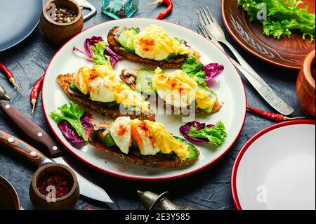 Pochiertes Ei, Gurke und geschmorte Pilze.Frühstück mit Eiern benedict.Classic Egg Benedict Stockfoto