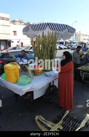 AGADIR, MAROKKO-DEZEMBER 13:Unidentifizierte Frau Kunden kaufen Zuckerrohrsaft vor Souk Al hatte.Dezember 13,2015 in Agadir, Marokko. Stockfoto