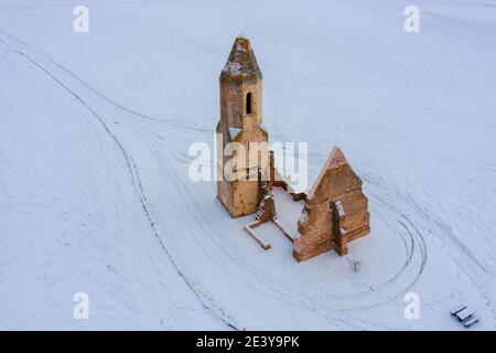 Somogyvámos, Ungarn - Luftaufnahme von Pusztatemplom, einer Kirche, die am Rande des Dorfes ruiniert. Winterlandschaft im januar. Verschneite Landschaft. Stockfoto