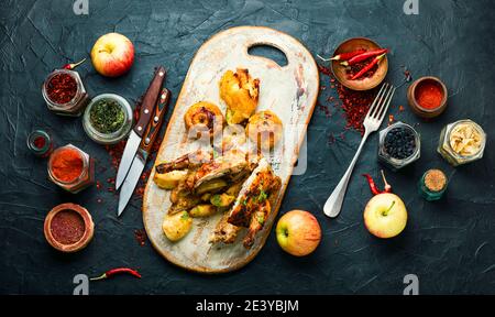 Hähnchen in Äpfeln gebacken, in Scheiben geschnitten auf einem Küchenbrett.gebackenes würziges Hähnchen Stockfoto