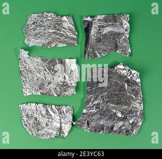 Verschiedene Folienstücke auf grünem Hintergrund, Draufsicht Stockfoto