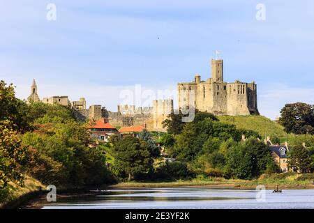 Blick auf den Fluss Coquet zu den Burgruinen von Warkworth aus dem 15. Jahrhundert über dem Dorf. Warkworth, Northumberland, England, Großbritannien Stockfoto