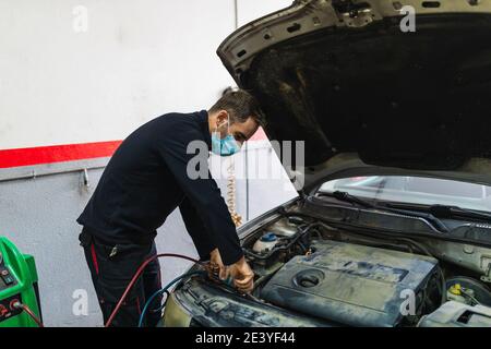 Mechaniker Reparatur Klimaanlage im Auto. Stockfoto