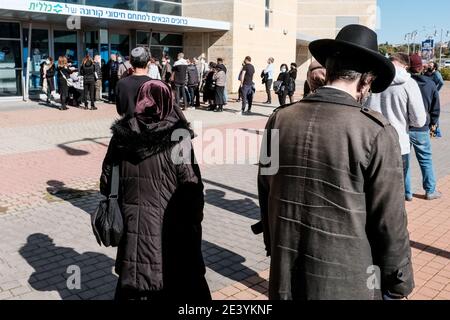 Jerusalem, Israel. Januar 2021. Mitglieder des Clalit Health Services warten auf den Erhalt von COVID-19-Impfstoffen im Pais Arena Sports Complex in Jerusalem, der in ein Coronavirus-Impfzentrum umgewandelt wurde. Kriterien sind nun entweder Gesundheitshelfer, Erziehende, schwangere Frauen oder die breite Öffentlichkeit im Alter von 50 Jahren und höher. Die Zahl der israelischen Bürger, die mindestens eine Dosis des Pfizer BioNTech-Impfstoffes erhalten haben, hat 2 Millionen überschritten, während eine Massenimpfkampagne fortfährt, und ebenso die COVID-19-Infektion in der Öffentlichkeit. Kredit: Nir Alon/Alamy Live Nachrichten Stockfoto