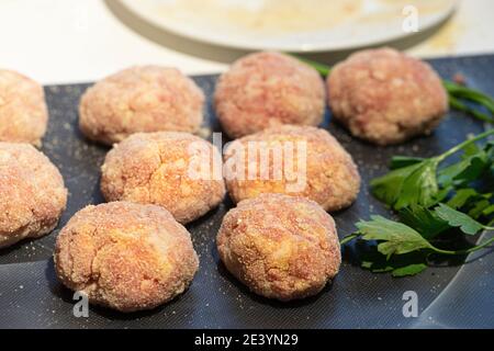 Kochen von Fleischschnitzel. Halbfertige Fleischbällchen auf einem Schneidebrett. Stockfoto