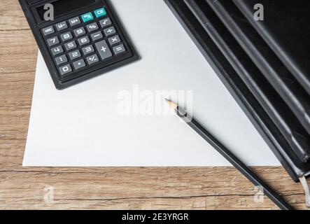 Stapel von persönlichen Leder begrenzt Zeitschriften. Schwarzer Bleistift auf leerem Papierrohling. Rechner. Holztisch Hintergrund. Nahaufnahme. Stockfoto