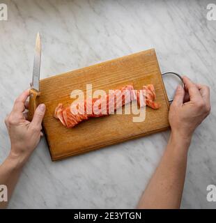 Frau gehackten gesalzenen Lachs auf Küchenbrett Stockfoto