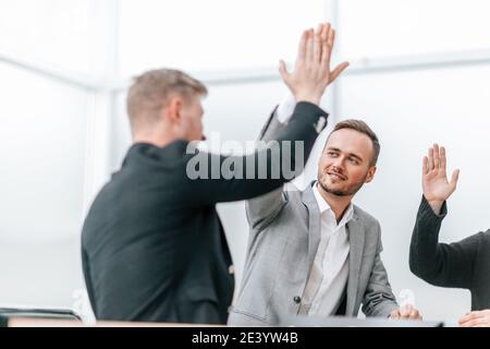 Junge Mitarbeiter geben einen hohen fünf Stockfoto