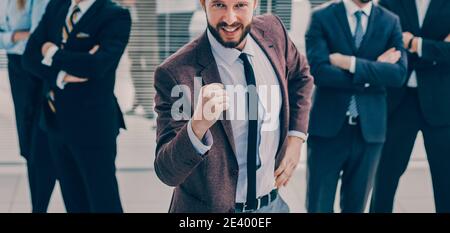 Glücklicher Anführer, der vor seinem Geschäftsteam steht. Stockfoto