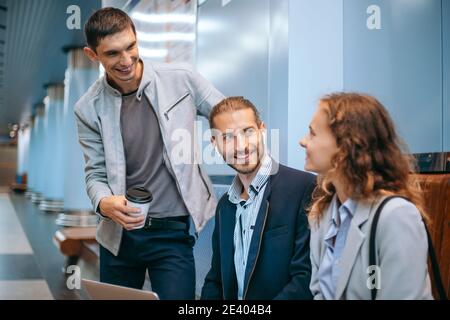 Junge Geschäftsleute mit einem Laptop auf dem U-Bahnsteig. Stockfoto