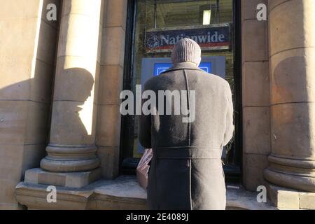 Glasgow, Schottland, Großbritannien, Street Life, Anonymous Mann mit Rücken zur Kamera verwendet einen Geldautomaten Stockfoto