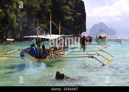 PALAWAN, PHILIPPINEN - 1. DEZEMBER 2017: Menschen fahren Outrigger bangka Boot auf Insel Hopping Tour in Palawan, Philippinen. 6 Millionen ausländische Touristen Stockfoto