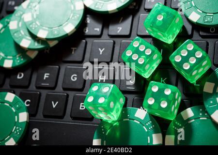 Casino Chips und Würfel Stapeln auf einem Laptop. Stockfoto
