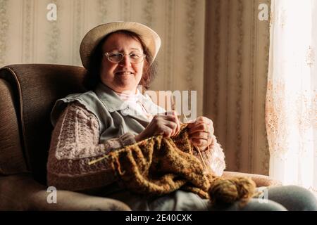 Ältere Frau Strickpullover für ihre Enkelkinder Stockfoto