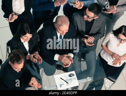 Draufsicht. Geschäftsteam applaudiert am Arbeitsplatz. Stockfoto