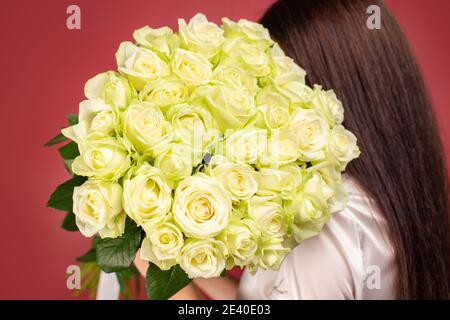 Das Mädchen mit einem großen Blumenstrauß auf ihr Schulter Stockfoto