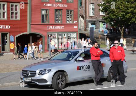 BERGEN, NORWEGEN - 23. JULI 2020: Taxifahrer warten im Stadtteil Bryggen in Bergen, Norwegen. Es ist ein UNESCO-Weltkulturerbe. Stockfoto