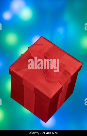 Rote Geschenkdekorbox mit roter Schleife auf buntem Hintergrund Stockfoto