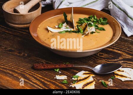 Schüssel Gemüsesuppe, Pita Brot, gesundes veganes Essen auf rustikalem Holztisch Stockfoto