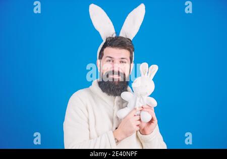 Guy bärtige Hipster niedlich sanften Hase lange Ohren blauen Hintergrund. Respekt vor Traditionen. Osterhase. Mann in Hase Plüsch Anzug. Lustige Häschen Mann mit Bart und Schnurrbart. Ostersymbol-Konzept. Stockfoto
