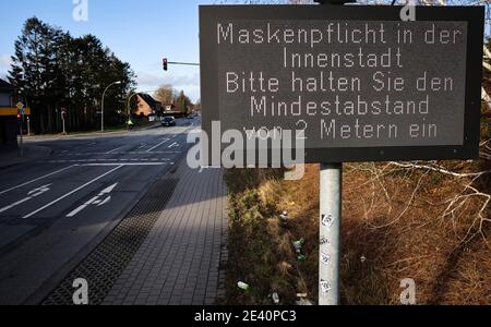 21. Januar 2021, Schleswig-Holstein, Neumünster: An einer Hauptstraße am Stadtrand von Neumünster steht ein Schild, das darauf hinweist, dass in der Innenstadt Masken vorgeschrieben sind. Foto: Christian Charisius/dpa Stockfoto