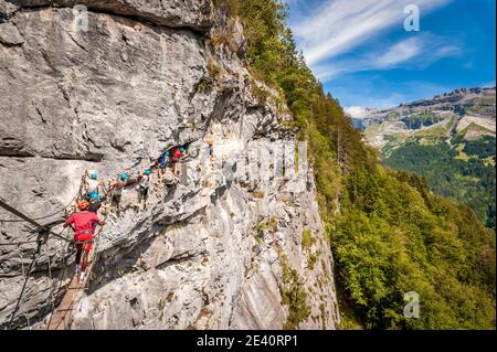 Klettersteig in Mont-Sixt-Fer-a-Cheval (Französische Alpen). Gruppe auf Klettersteig-Route, eine Mischung aus Wandern und Bergsteigen unterstützt durch kurze Seile, Kabel Stockfoto