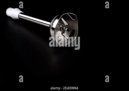 Elektrische Stabmixerdüse mit scharfer Klinge, die auf dem isoliert ist Dunkler Oberflächenhintergrund Stockfoto