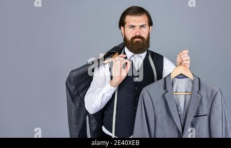 Bärtiger Mann Schneiderbekleidung. Formelle und Büro Garderobe. Geschäftsmann. Zuversichtlich Schneider Gestaltung männliche Jacke. Handsome sartor mit Band Maß. Männliche Schönheit und Mode. Copy space. Stockfoto