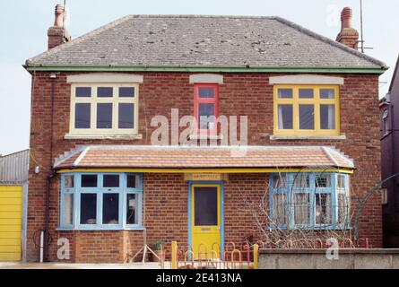 Brightville- 30s Einfamilienhaus mit Fenstern gelb rot und blau lackiert, brightville, eastington, glos Stockfoto