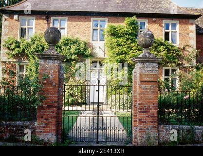 Dial House, 1691, Backsteinhäuser Blick durch schmiedeeiserne Torste auf Säule, Kreuzfenster, Sonnenuhr über Vordertür gesetzt, West lavington, wiltshire Stockfoto