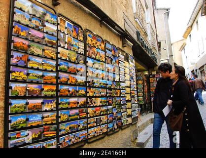 CARCASSONNE, FRANKREICH - 5. APRIL 2017: Touristen, die eine Postkarte aus dem mittelalterlichen Städtchen Carcassonne und seiner Burg kaufen möchten. Stockfoto