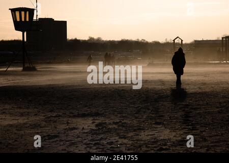 Kiel, Deutschland. Januar 2021, 21. Menschen, die am Strand bei stürmischem Wetter gegen das Licht laufen. Kredit: Frank Molter/Alamy Live Nachrichten Stockfoto