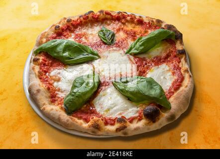 margherita Pizza mit Tomatenbasilsauce und Mozzarella Käse auf Orange gepunkteter Hintergrund Stockfoto