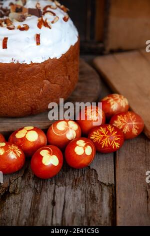 Osterkuchen und bunte Eier. Rustikales Essen auf einem Holztisch. Traditionelles Ei mit Zwiebelschale gefärbt. Muster aus Kleeblättern und Dillblättern. Klassisches Essen für Stockfoto