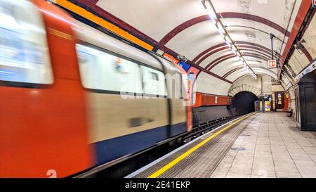 Eine U-Bahn, die mit Bewegungsunschärfen an einer Londoner U-Bahn-Station ankommt. Gut beleuchtete, helle Plattform ist leer von Passagieren. Northern Line, Hampstead. Stockfoto
