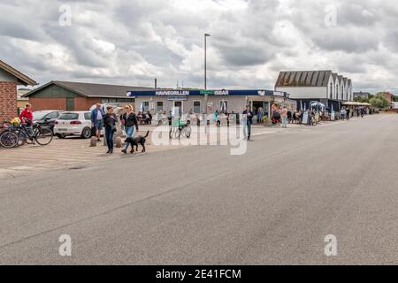 Bonnerup, Dänemark - 15. juli 2020: Der Hahn-Grill am Hafen in Bonnerup, Leute sitzen und essen vor dem Grill, wolkigen Himmel. Stockfoto