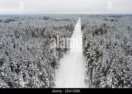 Winter schneebedeckten Nadelwald und die Straße aus dem Vogelauge Anzeigen Stockfoto