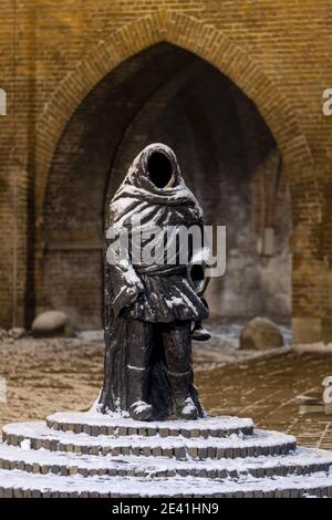 ZUTPHEN, NIEDERLANDE - 16. Jan 2021: Schnee auf der Statue des wagranten Straßenmusikers, dessen Name dem Drogenapstoren Stadteingang t gegeben wurde Stockfoto