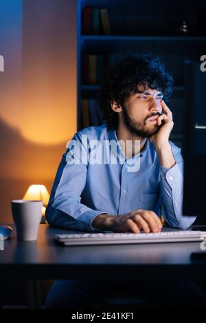 Nahaufnahme des schläfrigen Mannes, der spät in der Nacht arbeitet Computer reibt Augen zu Hause in dunklen Raum Stockfoto