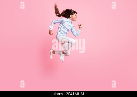 In voller Länge Körpergröße Ansicht der ziemlich motiviert fröhliche Mädchen Springen läuft schnelle Geschwindigkeit Energie isoliert über rosa Hintergrund Stockfoto