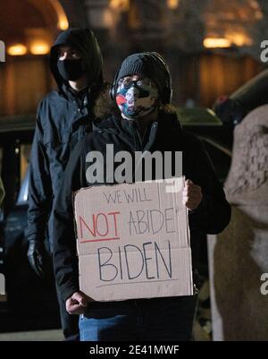 20. Januar 2021, Boston, Massachusetts, USA: Anti-Trump-Anhänger hält ein Zeichen "Wir werden nicht bleiben, Biden" während einer Kundgebung, die eine progressive Agenda für eine neu gewählte Biden-Harris-Regierung am Copley Square fordert. Quelle: Keiko Hiromi/AFLO/Alamy Live News Stockfoto