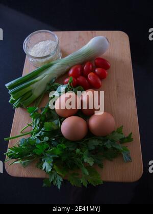 Stillleben im natürlichen Licht. Omelette Zutaten auf Holz Schneidebrett. Kochfotografie In Der Küche. Stockfoto