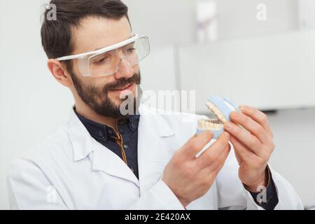 Nahaufnahme eines fröhlichen reifen männlichen Zahnarzt Untersuchung Zähne Schimmel, arbeiten in seiner Klinik Stockfoto