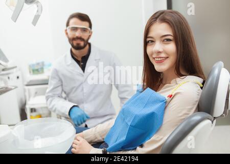 Junge schöne Frau lächelnd auf die Kamera sitzen in Zahn Stuhl im Zahnarztbüro Stockfoto