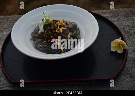 Schwarzer Reis Nudelsalat auf weißer Schüssel serviert Stockfoto