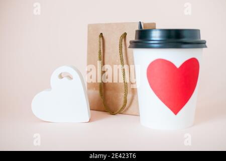 Papierbecher, Papiertüte und Herzfigur. Valentinstag Stockfoto