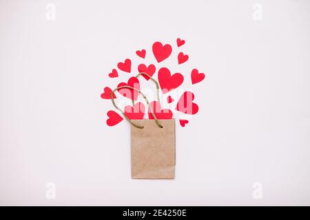 Geschenkpapierbeutel und rote Herzen fliegen aus ihm heraus. Valentinstag Stockfoto